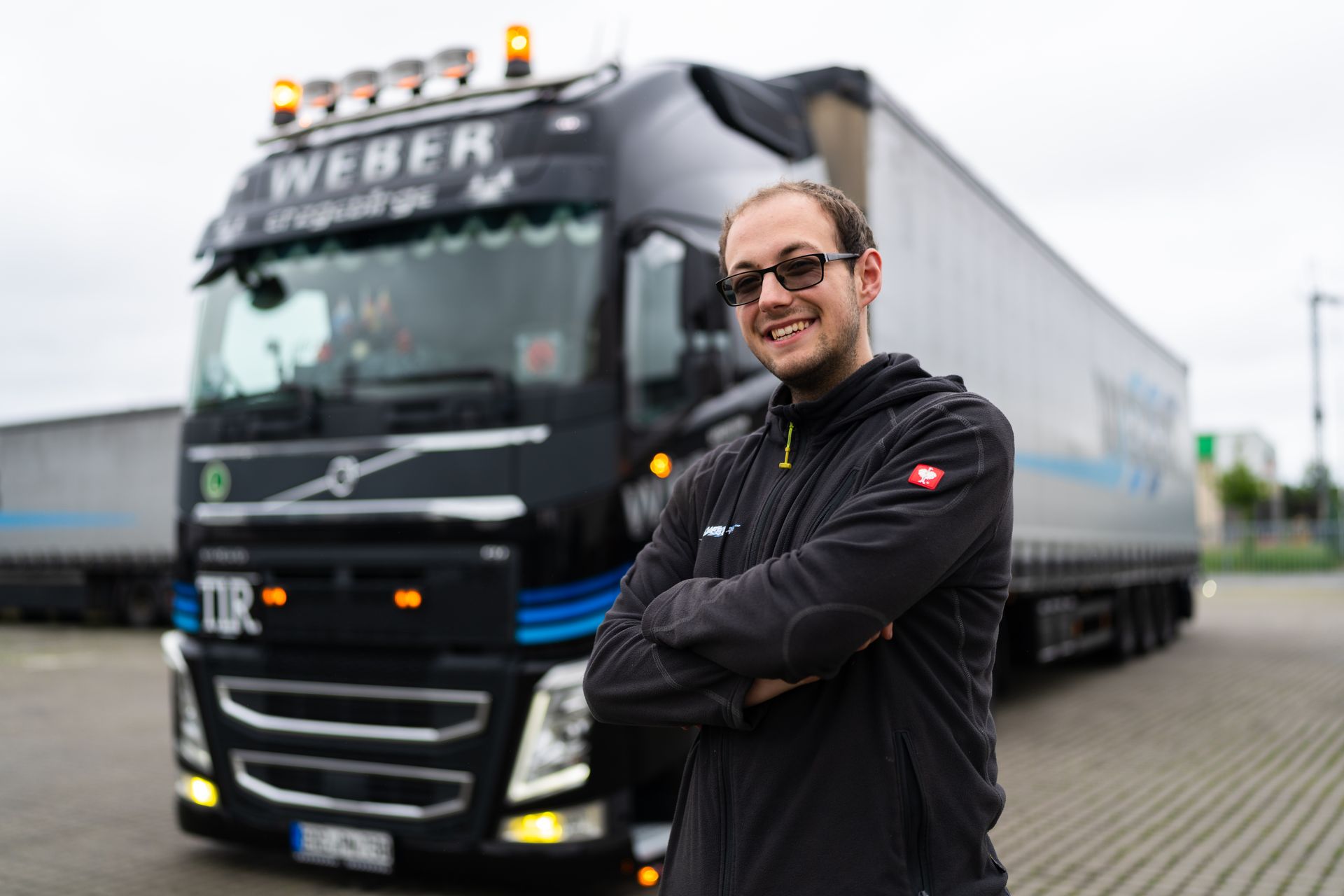 Fahrer der Spedition Weber vor seinem WEBER-LKW